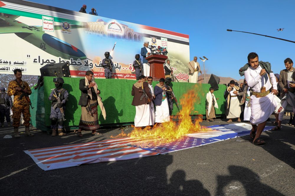 Houthi supporters burn Israeli and American flags during an anti-Israel rally in Sanaa, Yemen